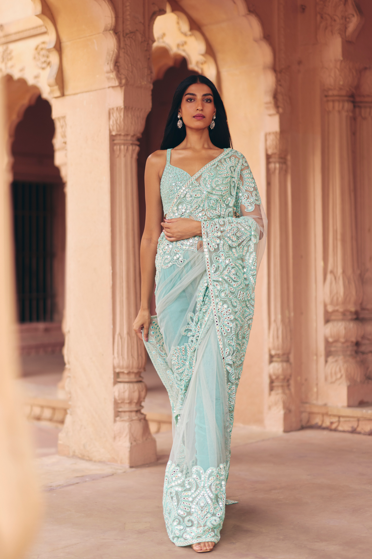 Aqua green mirror-embroidered blouse with a heavily embellished drape saree