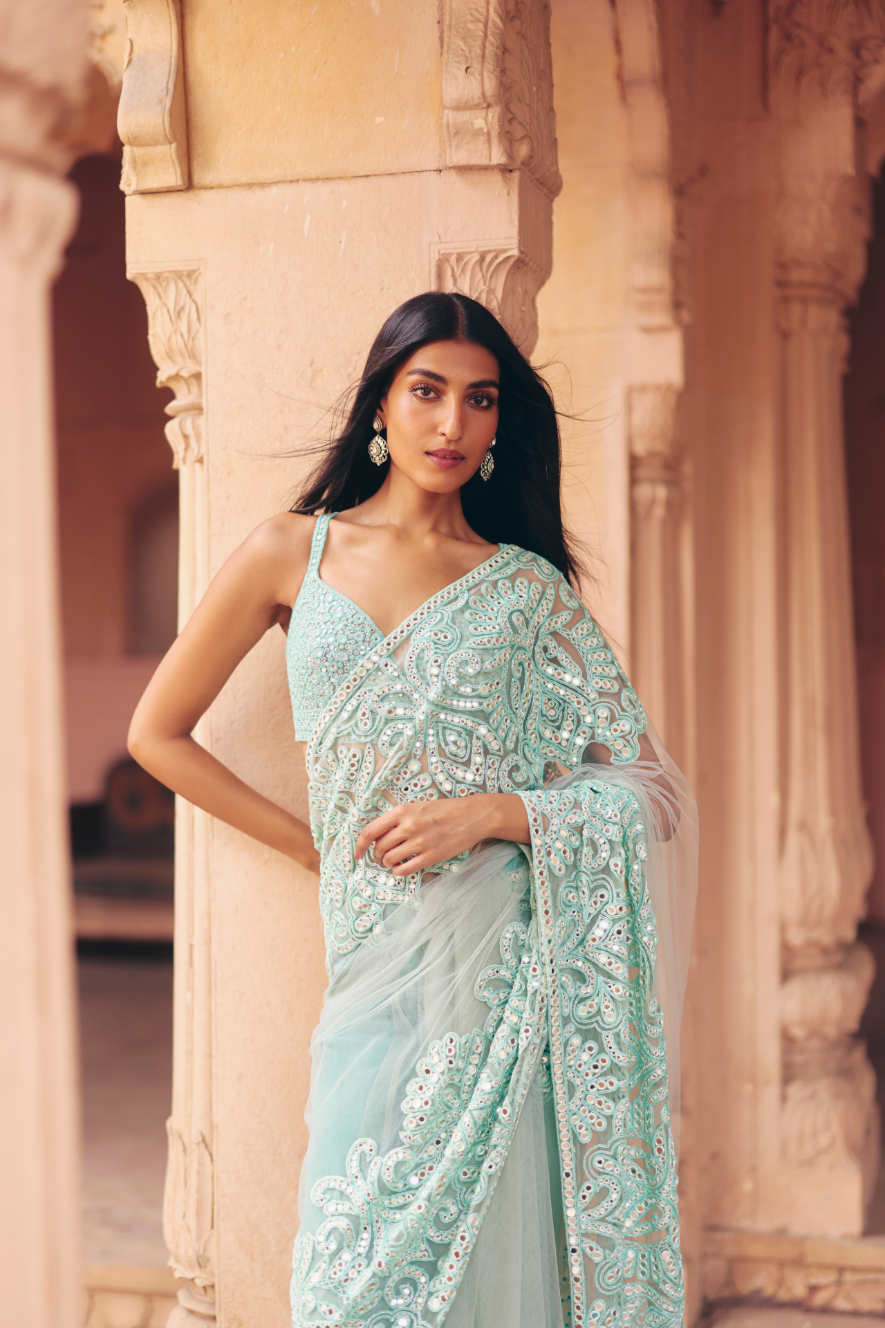 Aqua green mirror-embroidered blouse with a heavily embellished drape saree