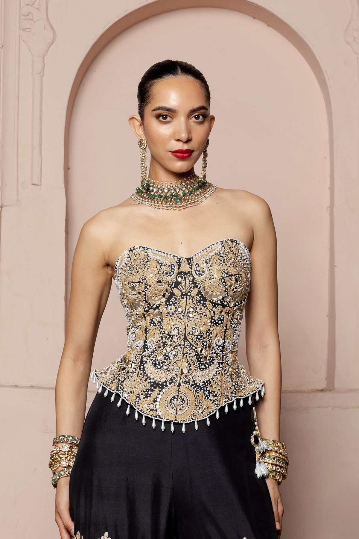 Black corset blouse and tiered sharara with gold cord and mirror embroidery