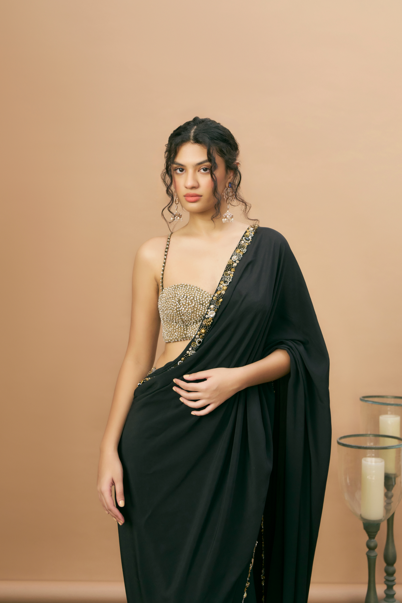 Black stone-embroidered corset blouse paired with a black pre-stitched saree with jewel-embroidered border
