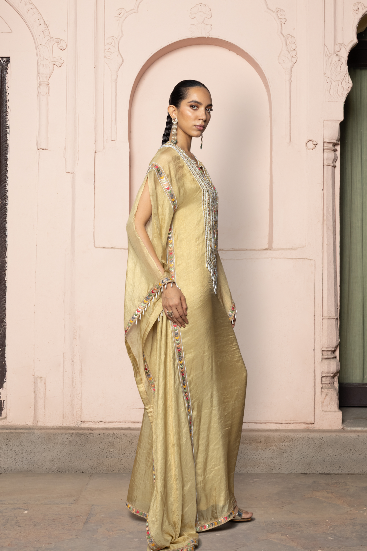 Gold kaftan with a mirror-embroidered neckline.