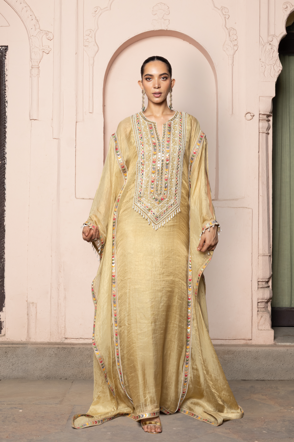 Gold kaftan with a mirror-embroidered neckline.