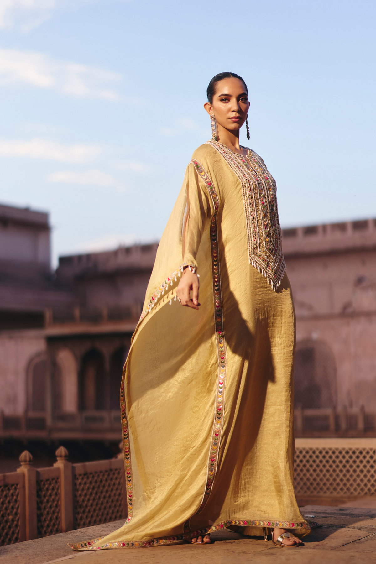 Gold kaftan with a mirror-embroidered neckline.