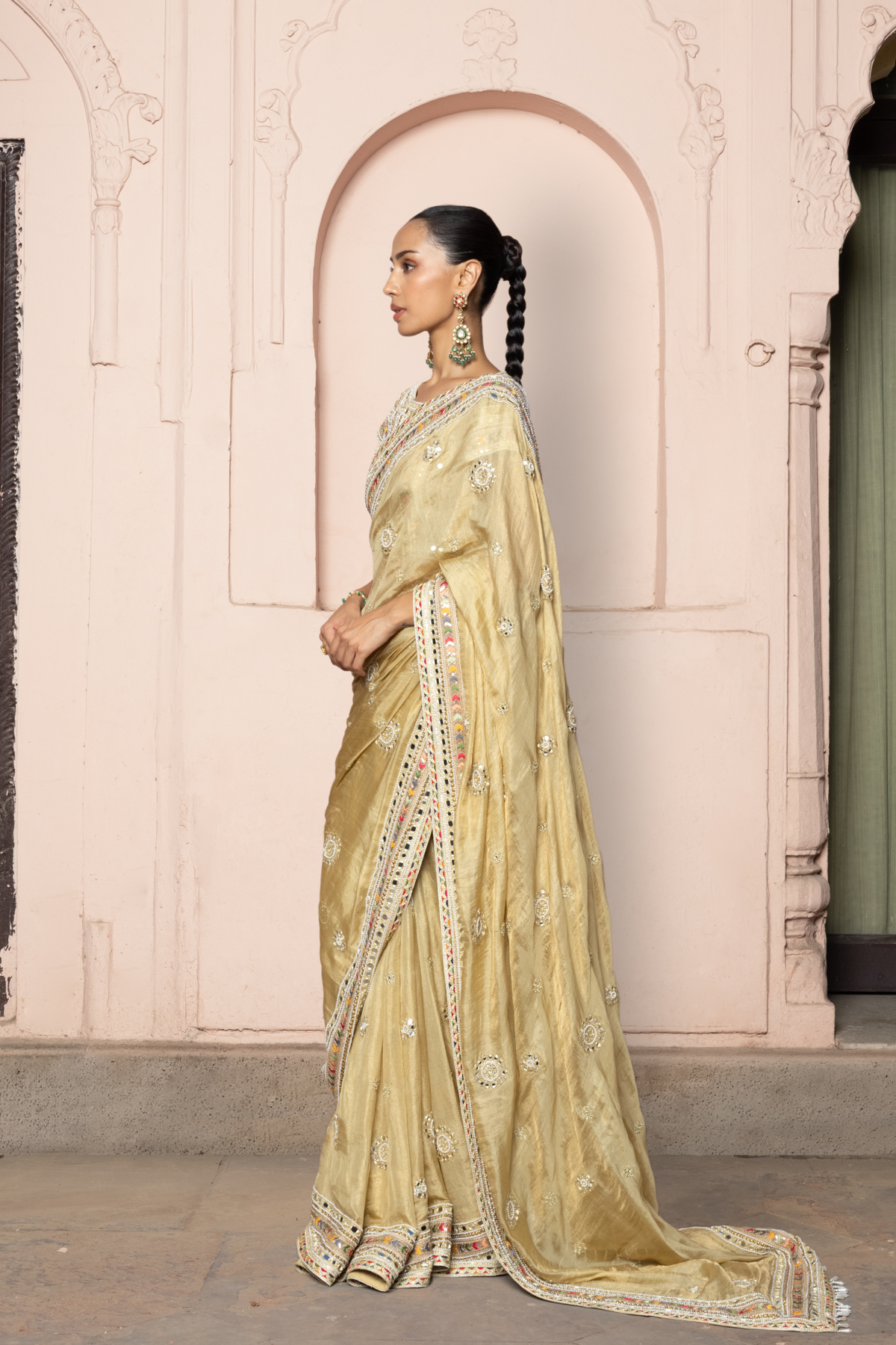 Gold saree with intricate mirror embroidery and sequin detailing, paired with a matching embroidered blouse.