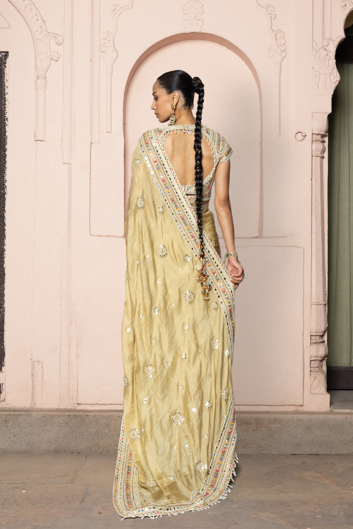 Gold saree with intricate mirror embroidery and sequin detailing, paired with a matching embroidered blouse.