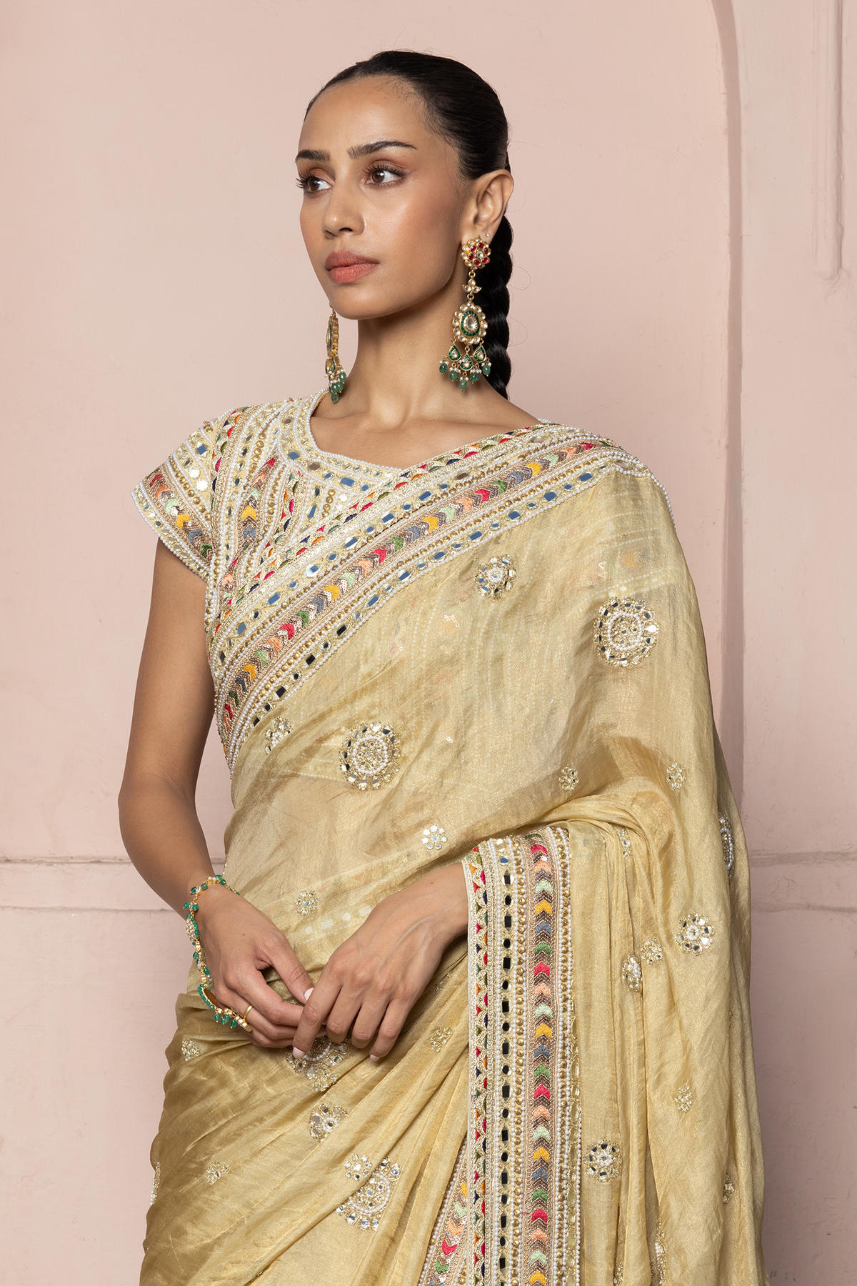 Gold saree with intricate mirror embroidery and sequin detailing, paired with a matching embroidered blouse.