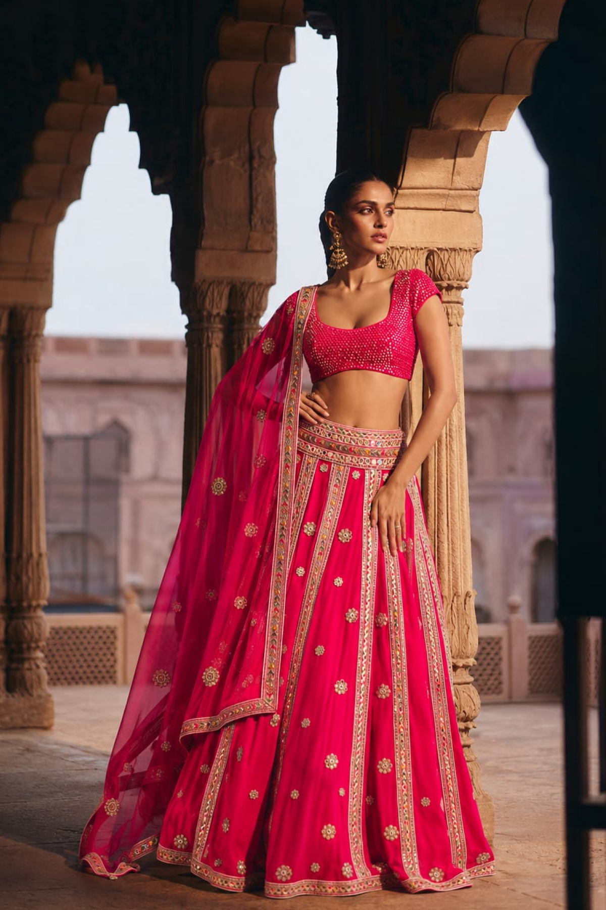 Hot pink mirror-embroidered blouse with a mirror-panelled lehenga and matching dupatta.