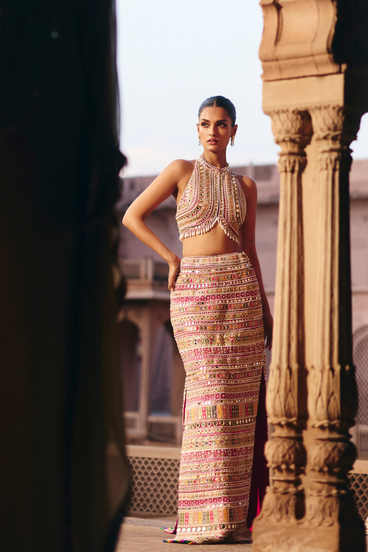 Hot pink straight skirt with embroidered borders and mirror embellishments, paired with a coordinating embroidered blouse.