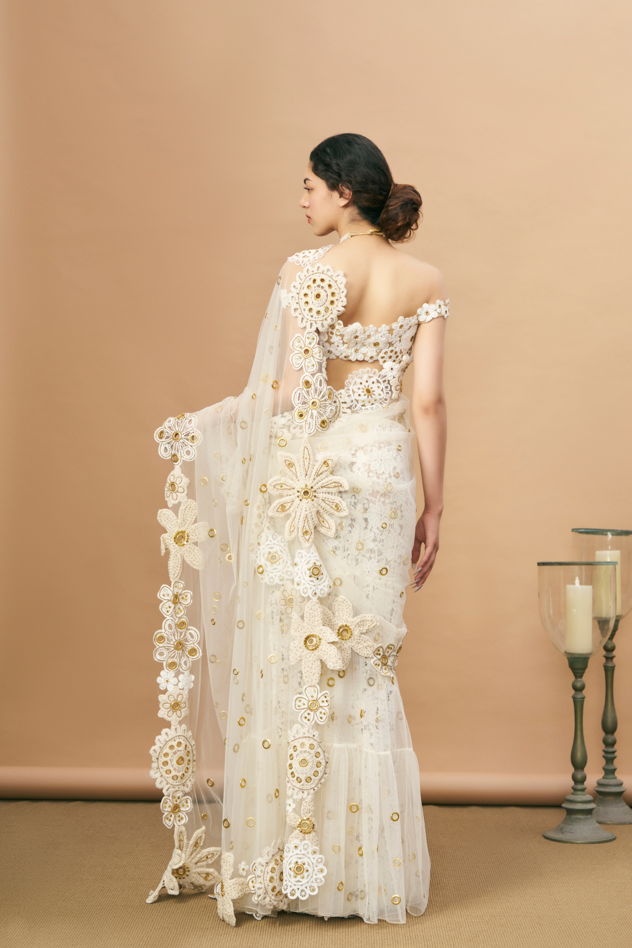Ivory crochet off-shoulder blouse and pre-stitched saree with a crochet-embroidered petticoat and gold rivet detailing
