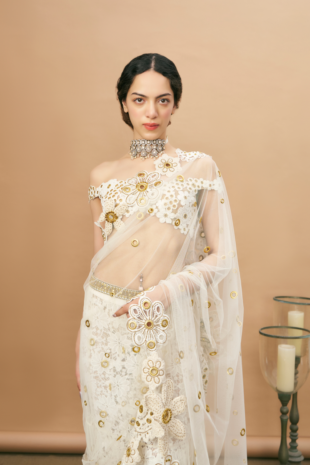 Ivory crochet off-shoulder blouse and pre-stitched saree with a crochet-embroidered petticoat and gold rivet detailing