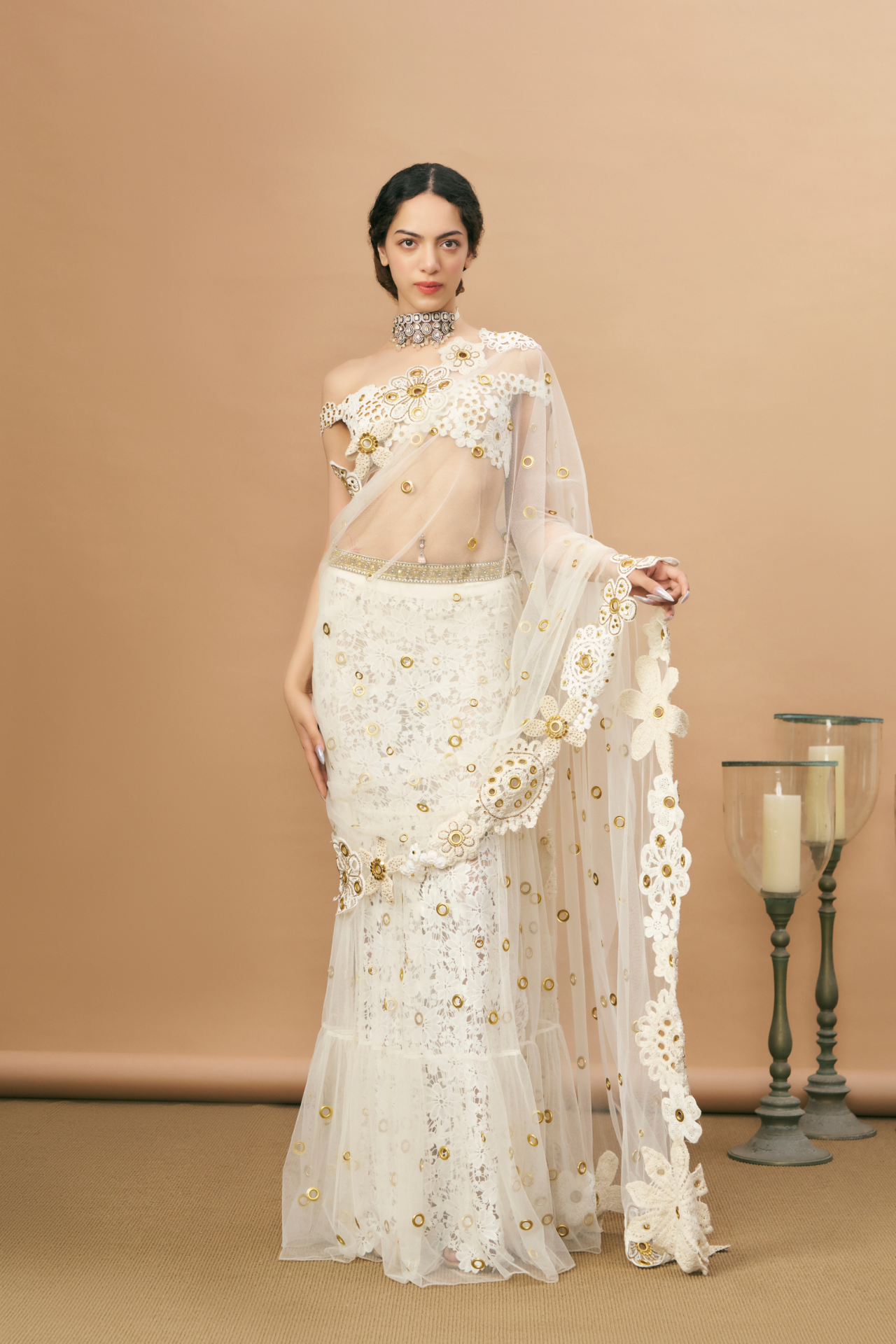 Ivory crochet off-shoulder blouse and pre-stitched saree with a crochet-embroidered petticoat and gold rivet detailing