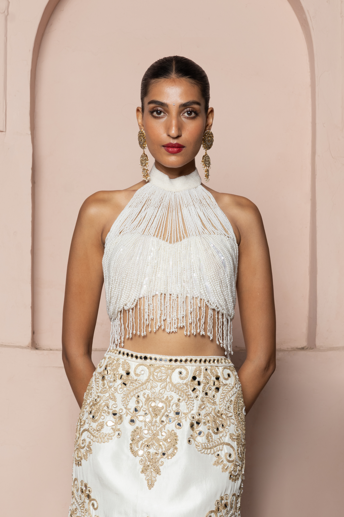 Ivory halter top with pearl tassels and a gold cord-embroidered skirt