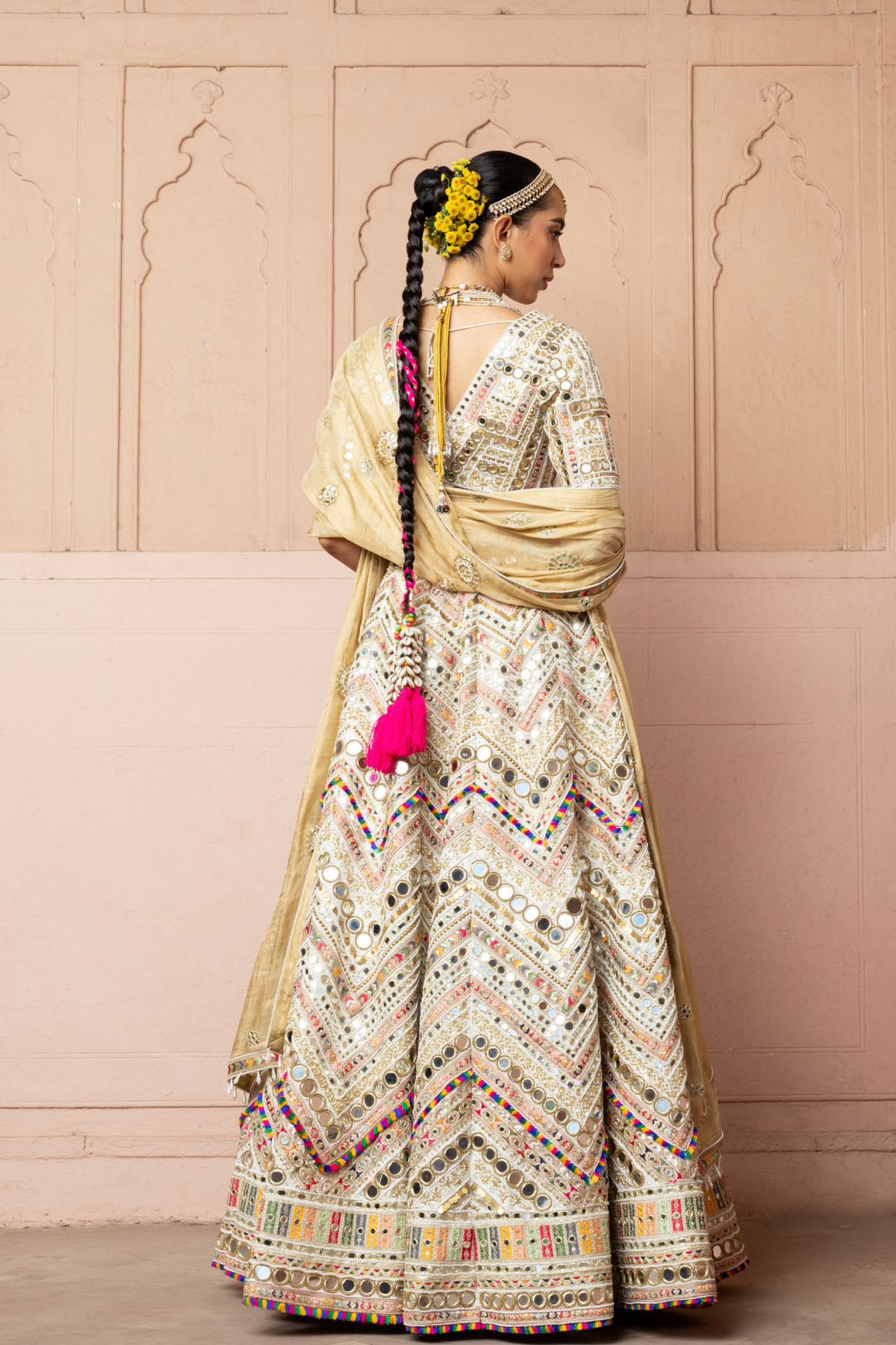 Ivory lehenga with intricate mirror embroidery, paired with a matching embroidered blouse and gold dupatta.