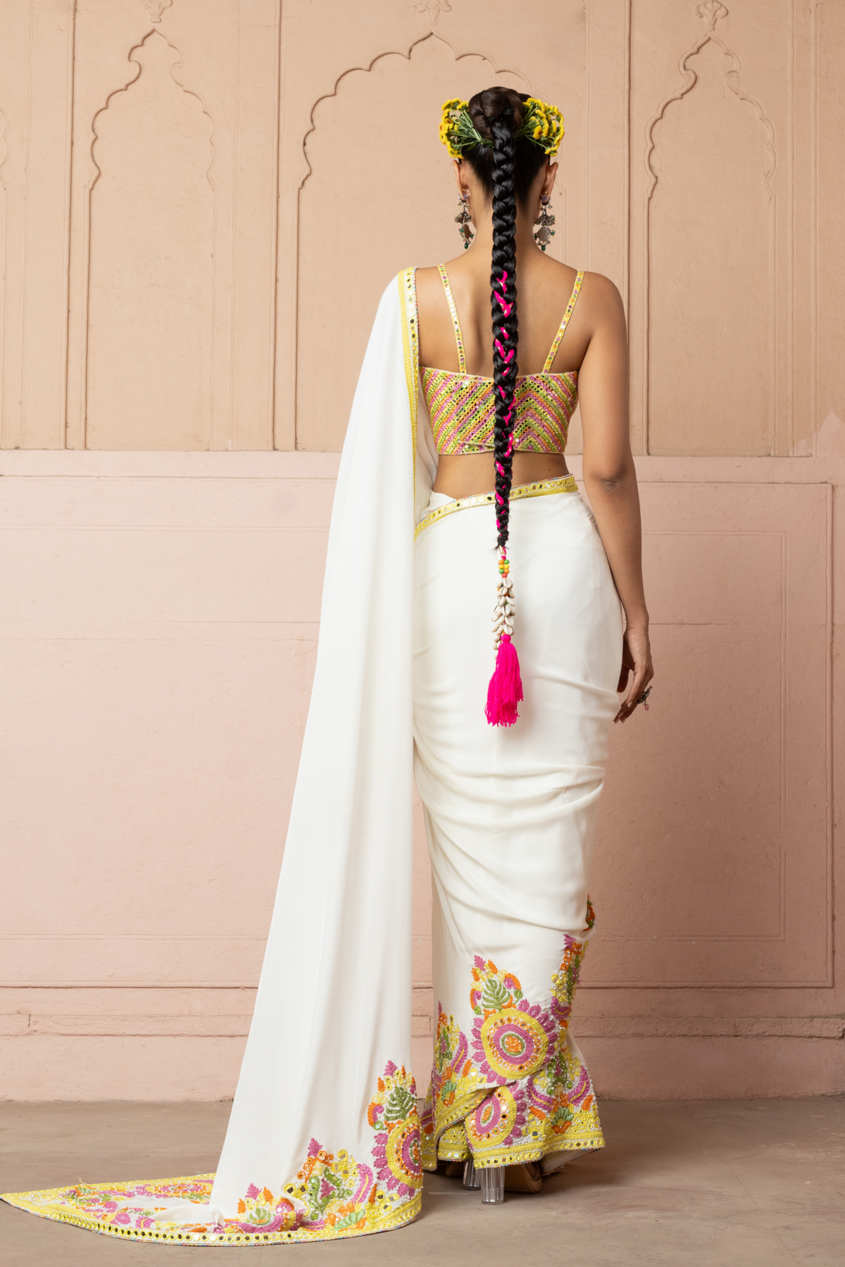 Multicolour mirror-embroidered blouse with an ivory saree featuring colourful cord embroidery.