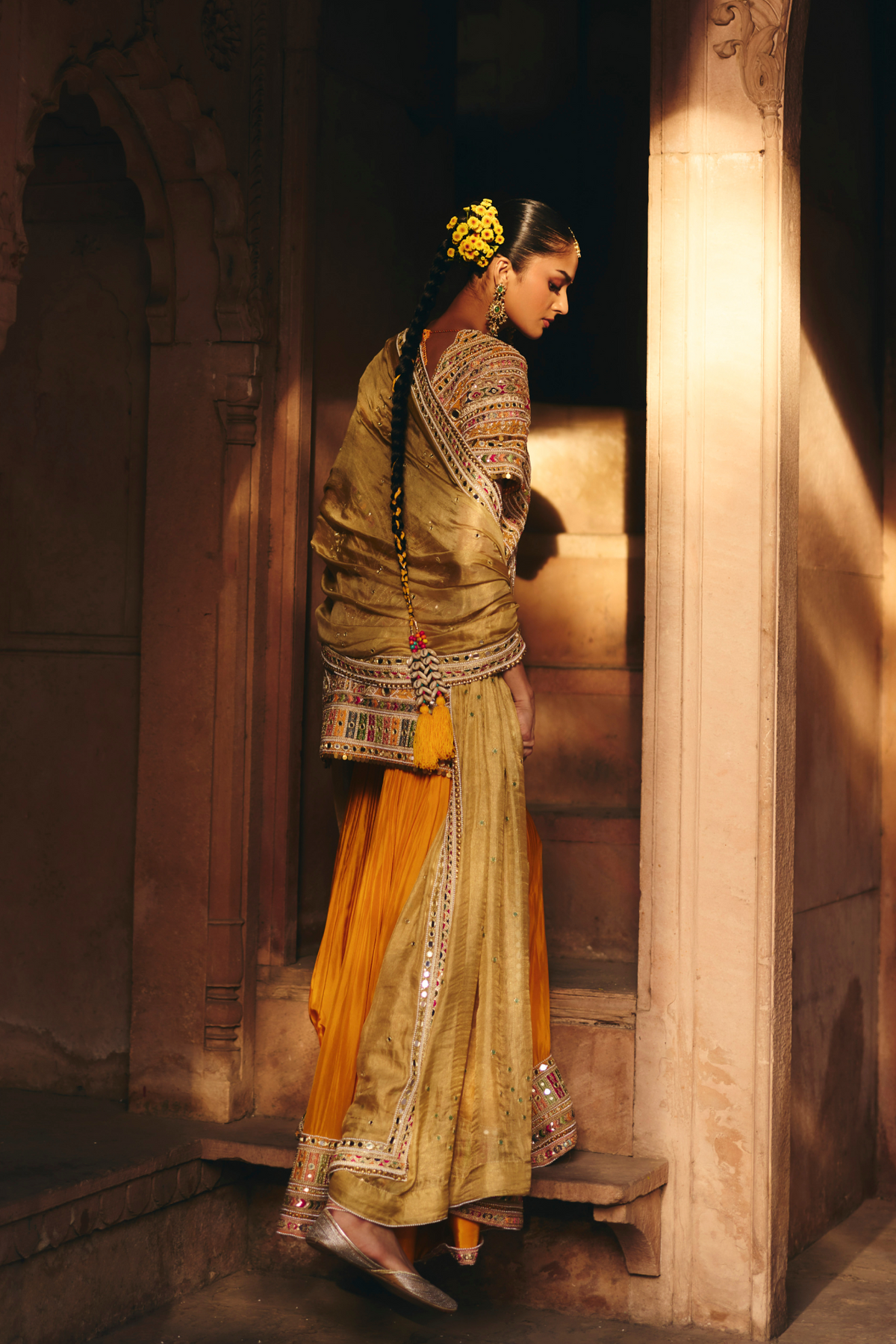 Mustard yellow embroidered kurta with mirror and threadwork detailing, paired with a coordinating flared sharara and gold dupatta.