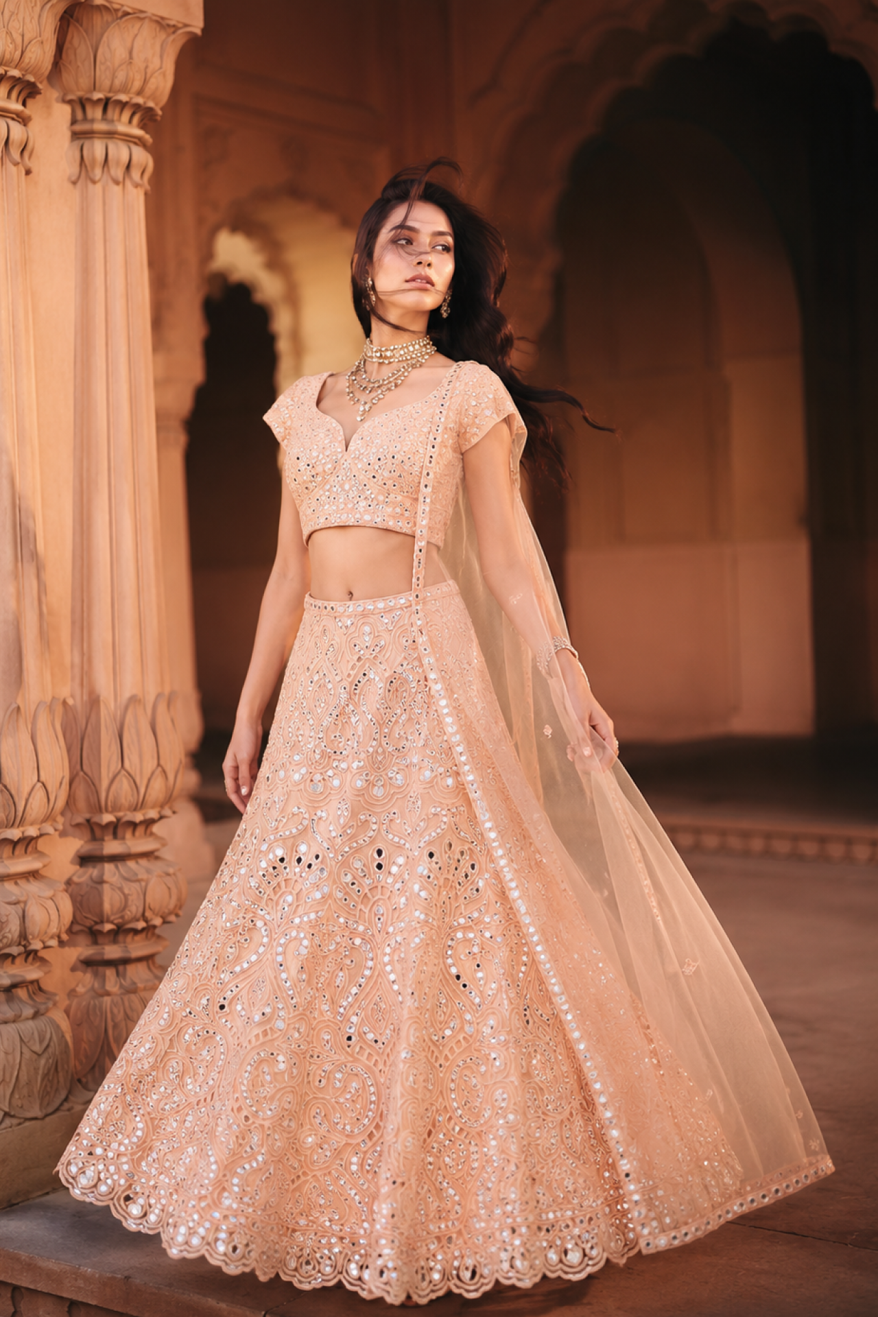 Peach mirror-embroidered fitted blouse with a flared lehenga and soft net dupatta